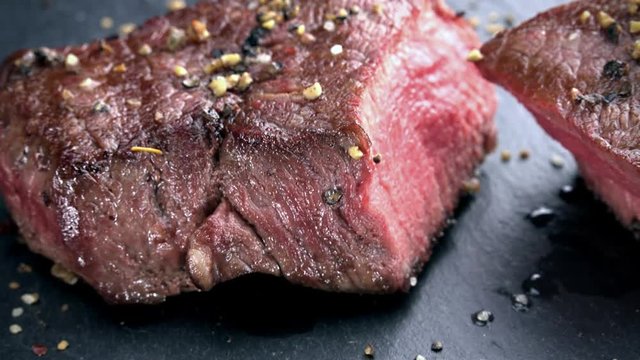 Grilled Beef as not loopable 4K UHD footage on a slate slab