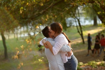 Fototapeta premium Man lifts girlfriend up in his arms