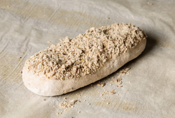 Raw leavened loaf of bread on baking paper in a bakery. The concept of baking and pastry shops.