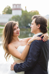 Young smiling bride and groom close portrait in summer park