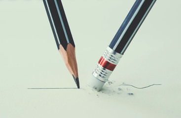 Close up of a pencil eraser removing a crooked line and the clos