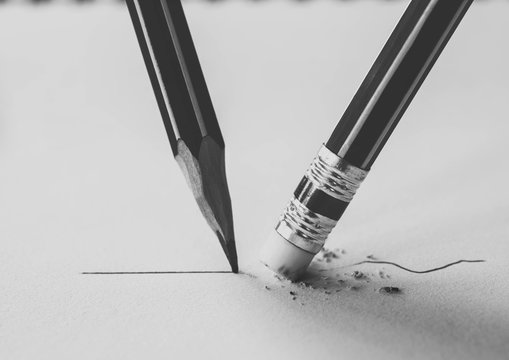 Close up of a pencil eraser removing a crooked line and the clos