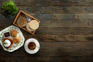 Scones with coffee and sour cream on wood background. View from above.