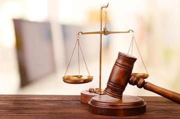 Judge's gavel and scales on blurred computers background