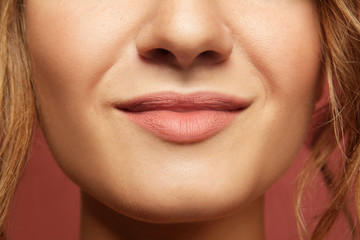 Closeup lips of smiling beautiful young woman with nude make up