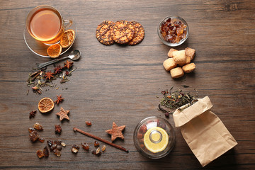 Ingredients for tea drinking on wooden background, flat lay