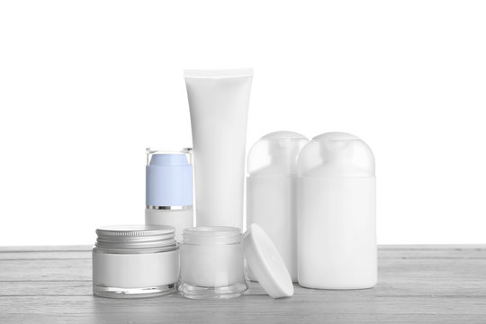 Different cosmetic bottles on table on white background