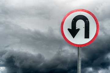 U turn sign on white dark cloud background with clipping path © santagig