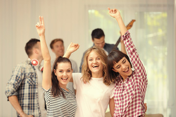 Happy friends listening to music at home