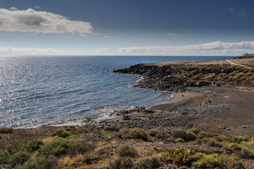 Fototapeta na wymiar Playas de arena negra volcánica , callados y piedras en Tenerife, Océano Atlántico