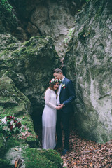 Elegant bride and groom posing together outdoors on a wedding day
