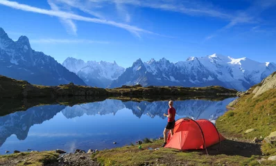 Foto op Plexiglas Wandelaar die geniet van het uitzicht op zijn rode tent in de bergen bij Chamonix, Frankrijk. © sanderstock