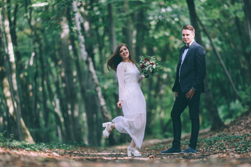 Elegant bride and groom posing together outdoors on a wedding day
