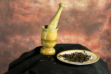 Mortar and pestle with cloves in plate