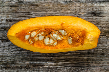 Cut pumpkin slice on wooden background, top view
