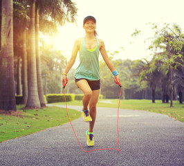 young fitness woman skipping rope at tropical park