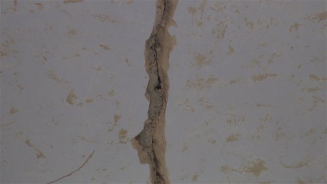earthquake cracked buildings/large crack on the wall in the room after earthquake disaster