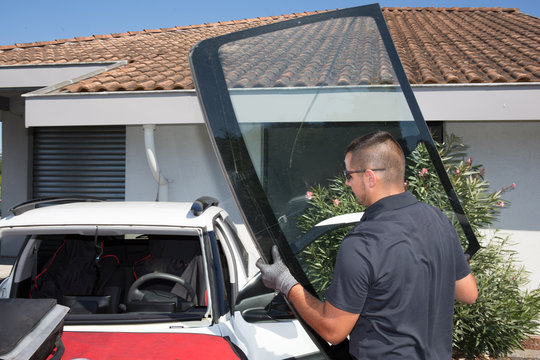 Glazier removing windshield or windscreen on a car