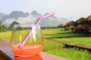 Apple juice on wooden table with nature background