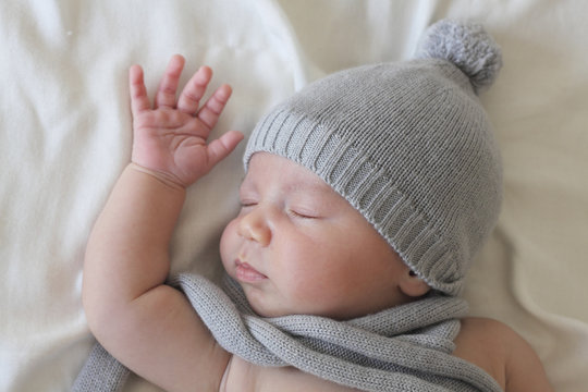 sleeping newborn with hat and scarf
