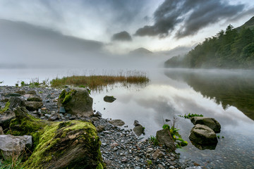 Dramatic sunrise with mist over lake at Buttermere in the English Lake District.