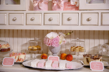 Different kinds of sweets lie under buffet shelves