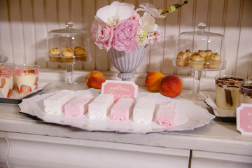 Buffet with sweets deocrated in pink and white tones
