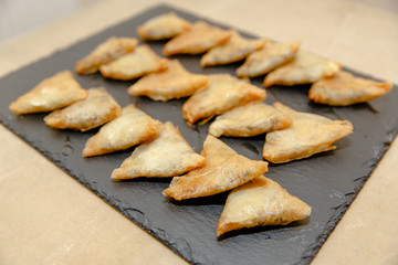 Pretty baked envelops lie on the dark brown plate