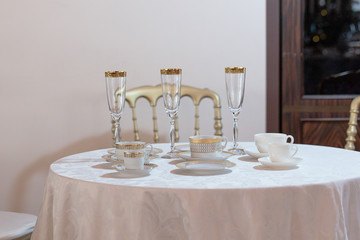 Demitasses, tea cups and champagne flutes stand on a little roun