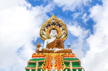 Obraz premium big colorful buddha statue sitting thai temple on blue sky background 