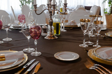 Rich bronse candlestick stand in the middle of festive dinner ta