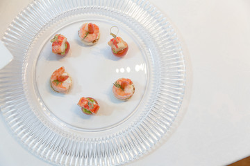 Appetizers made of shrimps lie on a glass plate