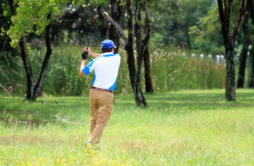 soft focus, male golfer hits golf ball from fairway