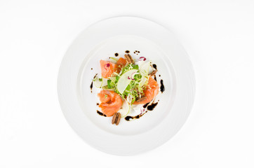 Marinated salmon with feta cheese, green apple, pecan and soy sauce on a plate on a white...