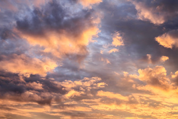 Romantic sunset sky with fluffy clouds
