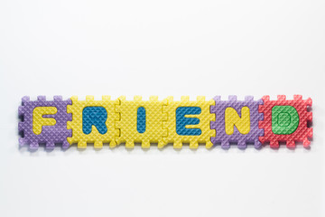 Puzzle pieces with word friend on a white background.