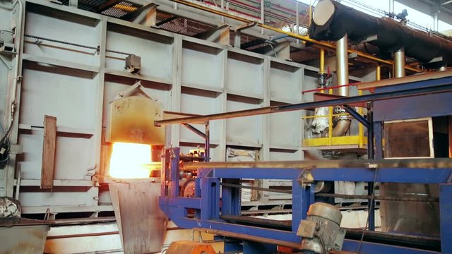 Ironworks plant. Machine pushing billet to furnace