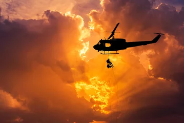 Fototapete Hubschrauber silhouette soldiers in action rappelling climb down with military mission counter terrorism assault training on sunset background 