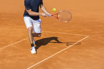 Foto op Canvas Male tennis player in action on the clay court on a sunny day © smuki