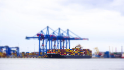 Fototapeta na wymiar Tilt-shift panoramic view of sea port with ship, cargo, containers and lorry