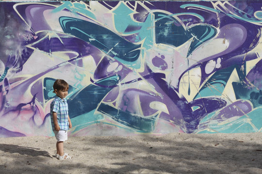 baby with a graffiti cold color wall background