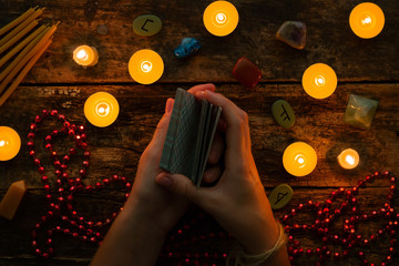 fortuneteller reads fortunes by tarot cards and candles on the background of the runes - obrazy, fototapety, plakaty