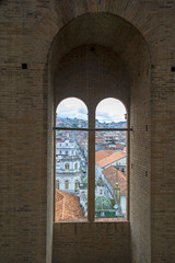 Window opening with a view to the city below, inside the towers of the Cuenca Cathedral, Ecuador.