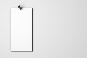 Blank white poster pinned to a plain wall with pushpins