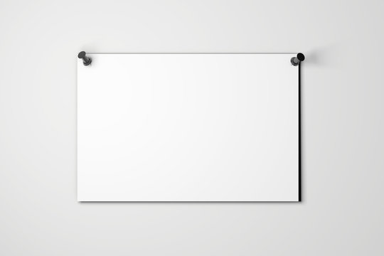 Blank white poster pinned to a plain wall with pushpins