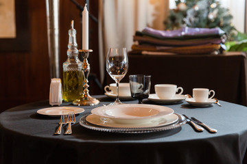 Lonely candle stands on the table served for one person