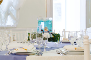 A bowl with blue water stands in the middle of a restaurant tabl