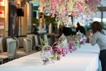 A ray made of pink and violet flowers stands in the middle of re