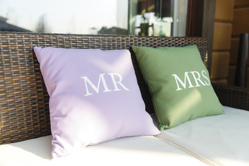 Violet and green pillows lie on the brown sofa