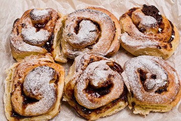 Homemade fresh baked yeast buns with plum jam. Sprinkled with icing sugar.